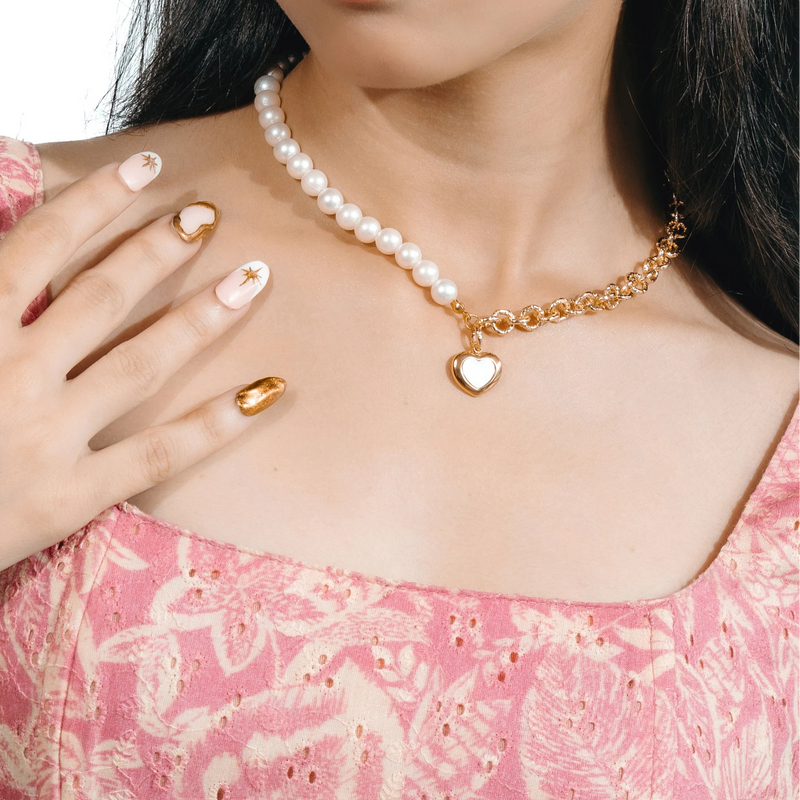 Woman wearing a pearl necklace, bracelet, and ring on a white background