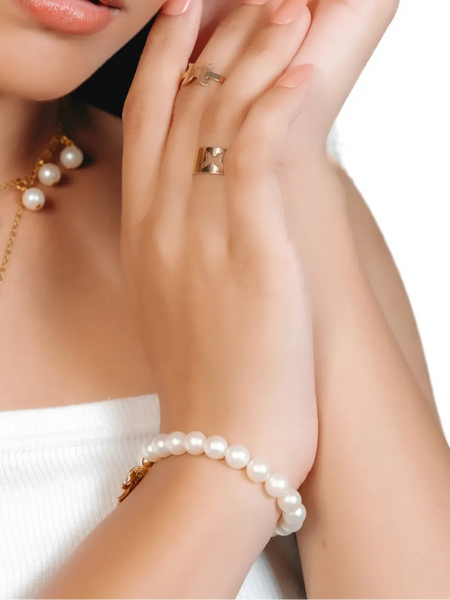 Woman wearing pearl necklace and bracelet with a white background
